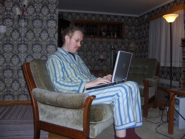 Middle-aged man in pajamas with Dell laptop PC